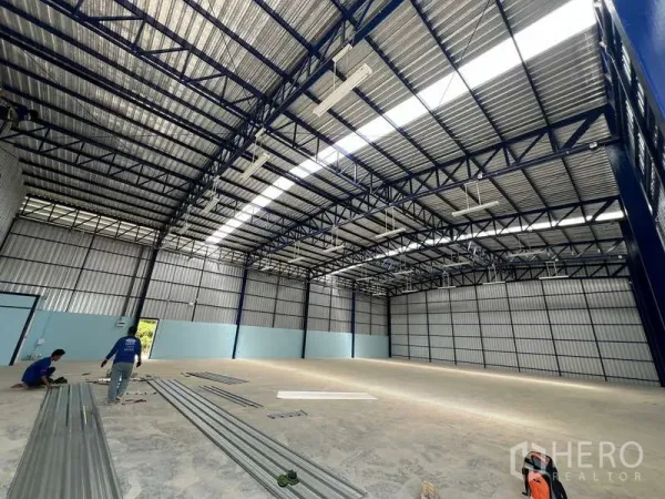 Warehouse for rent in Lat Krabang, Bangkok - Spacious warehouse interior with steel truss roof, skylights, bright lighting and smooth concrete floor.