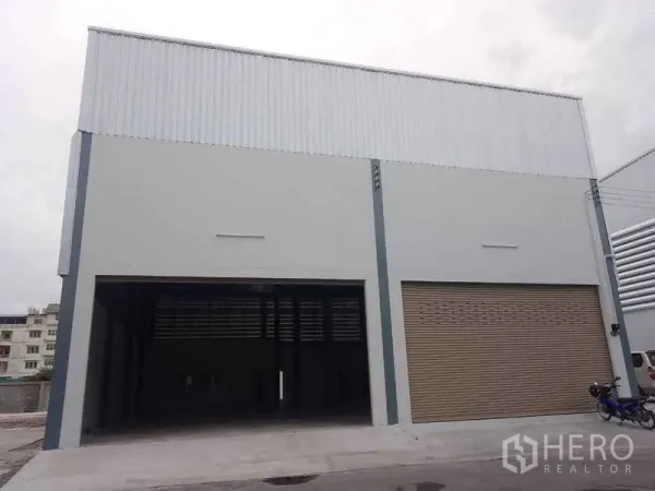 Warehouse for rent in Khlong Toei, Bangkok - Front view of a modern warehouse with a tall loading bay and a large roller shutter.