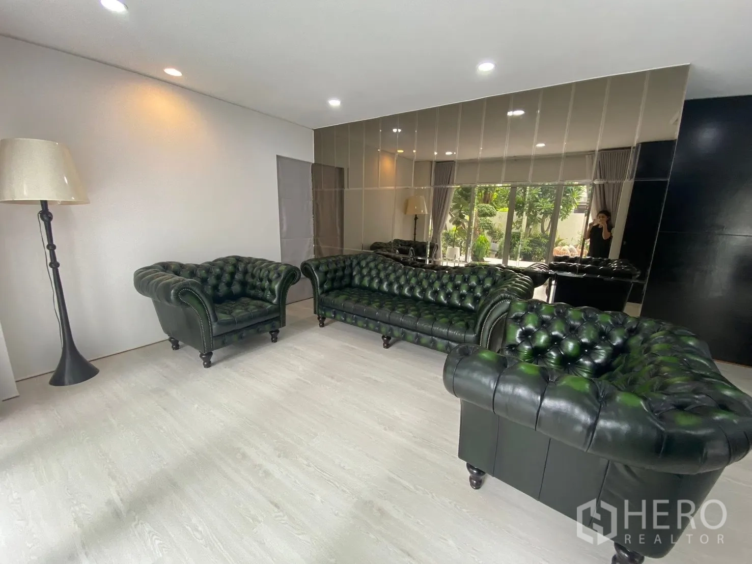 Detached House for rent in Suan Luang, Bangkok - Lounge with mirrored accent wall and a full Chesterfield sofa set.