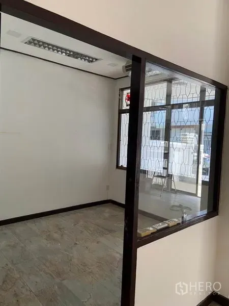 联排别墅 出租在Khlong Toei, Bangkok - 带玻璃隔断的小房间，白色墙面、瓷砖地面与带花纹防盗窗的窗户。