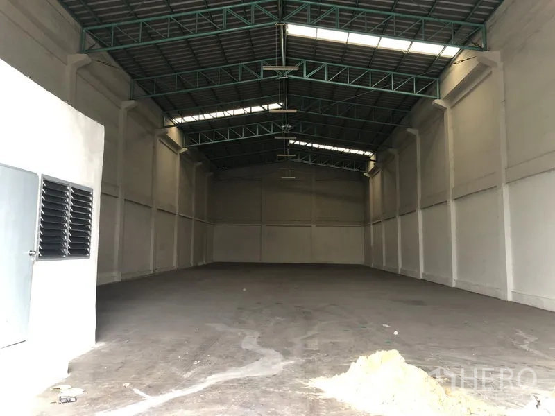 Warehouse for rent in Khlong Luang, Pathum Thani - Spacious empty warehouse interior with high steel truss roof and skylights.
