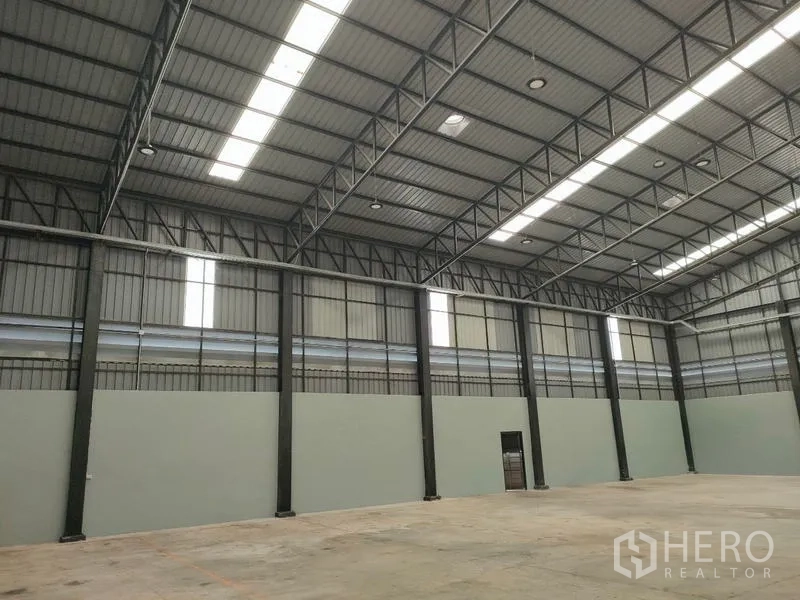 Factory for rent in Ban Phaeo, Samut Sakhon - Warehouse wall with rows of steel columns and roof lights.