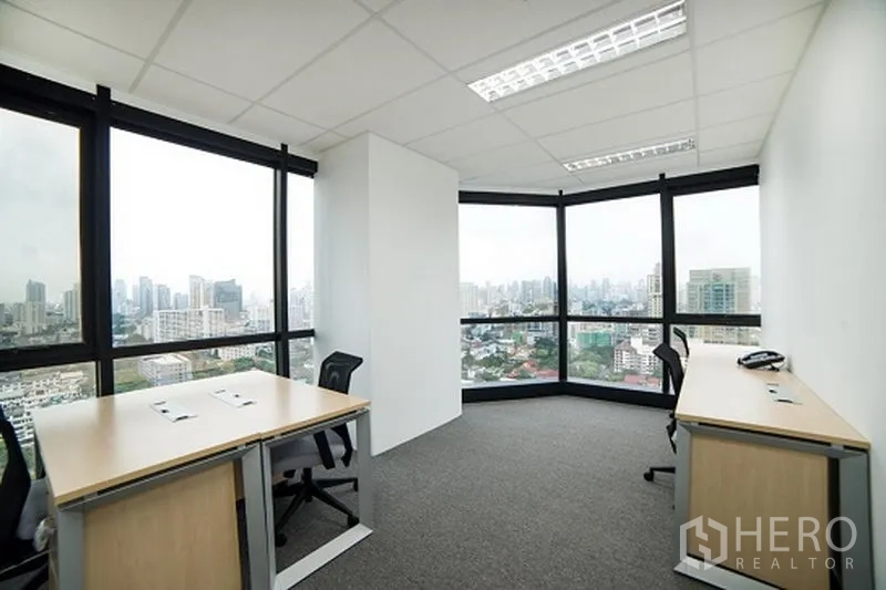 Office Space for rent in Khlong Toei, Bangkok - Corner office with wraparound windows, two desks and panoramic skyline view of Bangkok.