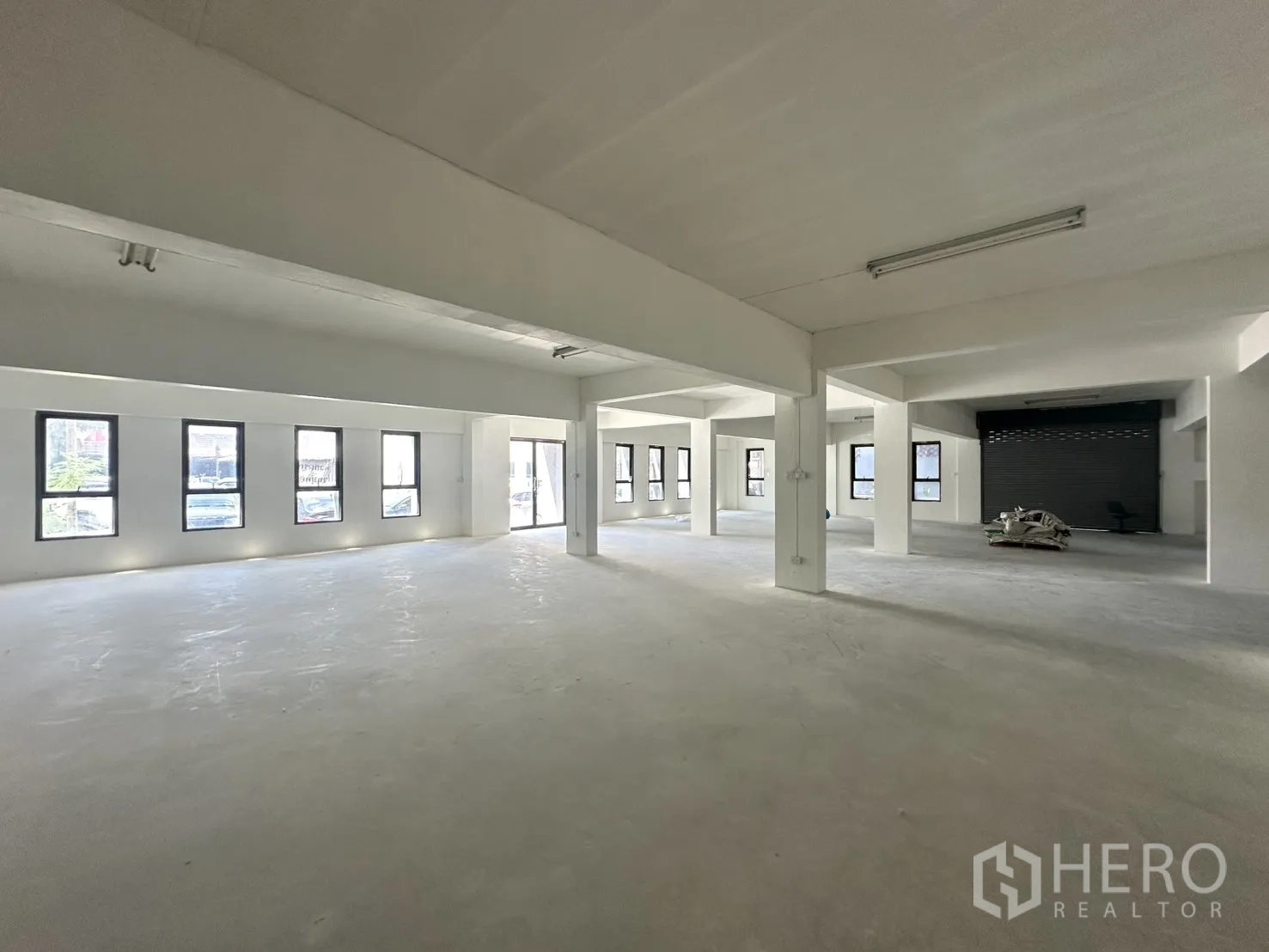 Warehouse for rent in Bang Phli, Samut Prakan - Open-plan level with tall windows and roller shutter access.