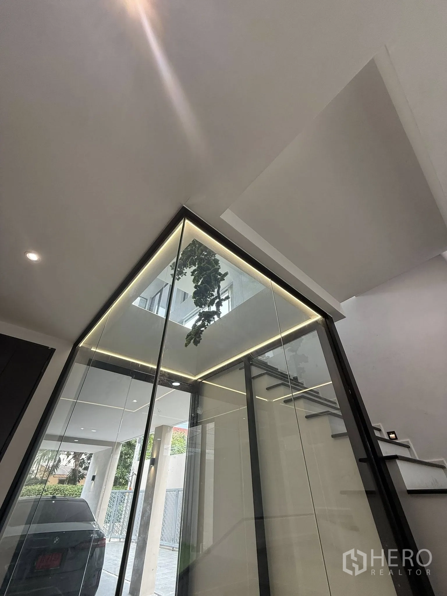 Home Office for rent or sale in Lat Phrao, Bangkok - Glass-enclosed lightwell beside the entrance and stairs leading to upper floors.