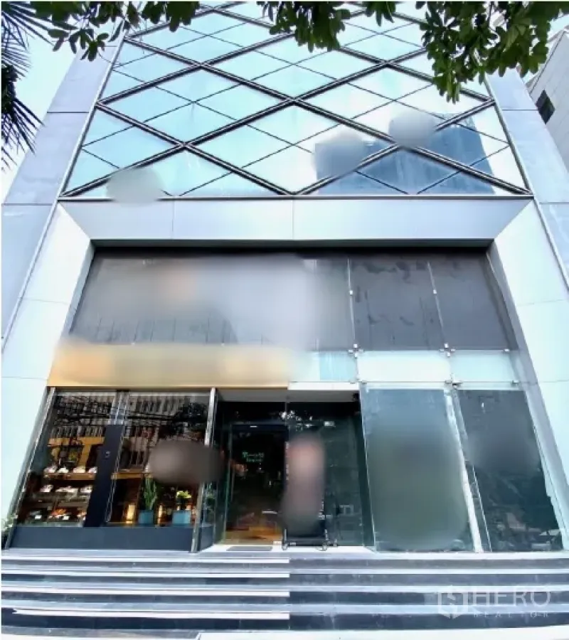 Retail Space for rent in Watthana, Bangkok - Modern glass-front commercial building entrance with wide steps and double-height retail frontage.