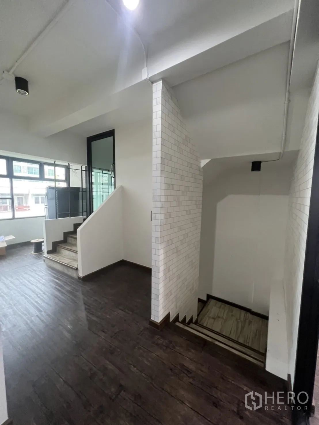Retail Space for rent in Watthana, Bangkok - Stair landing with white subway tiles, dark wood floors and natural light from wide windows.