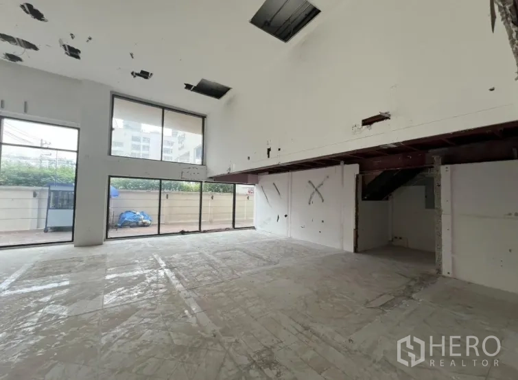 Retail Space for rent in Watthana, Bangkok - Large double-height showroom area with mezzanine and long windows.