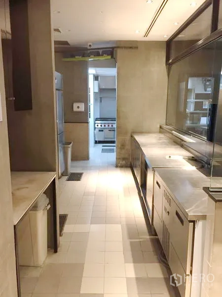 Retail Space for rent in Khlong Toei, Bangkok - Commercial kitchen corridor with stainless steel counters, refrigerators and tiled flooring.