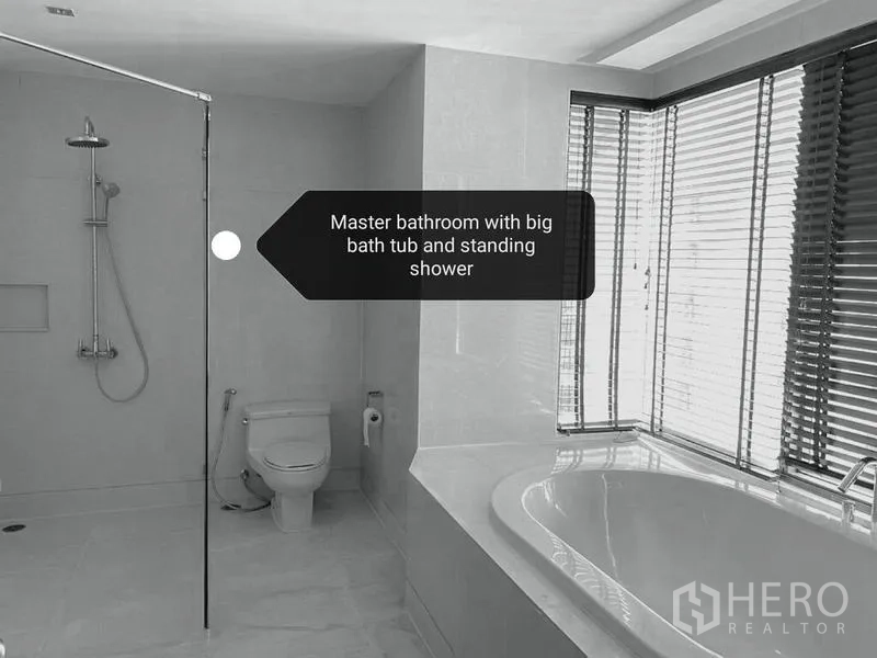Condominium for rent - Master bathroom featuring soaking tub, glass shower and corner windows with blinds