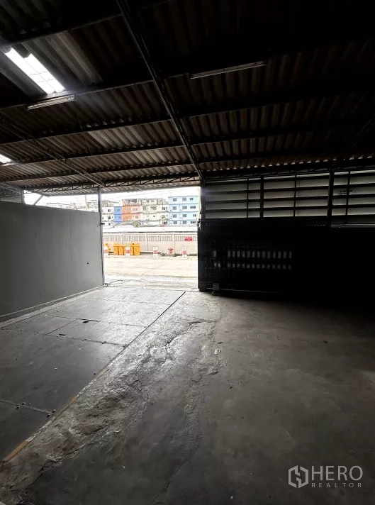 Factory for rent in Bang Phli, Samut Prakan - View from the loading dock toward the street through a large opening.