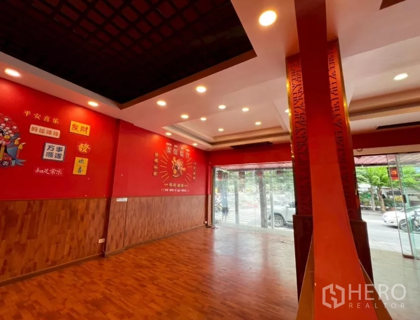 Shophouse for rent in Watthana, Bangkok - Open storefront corner with floor-to-ceiling windows and recessed lighting.