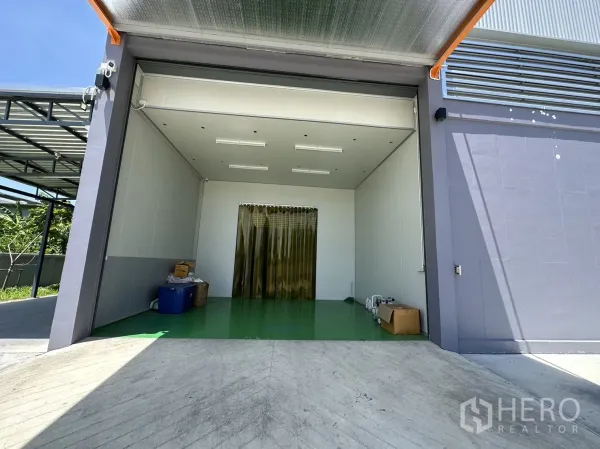 Factory for sale in Lam Luk Ka, Pathum Thani - Clean loading room with ramp and yellow PVC strip curtains.