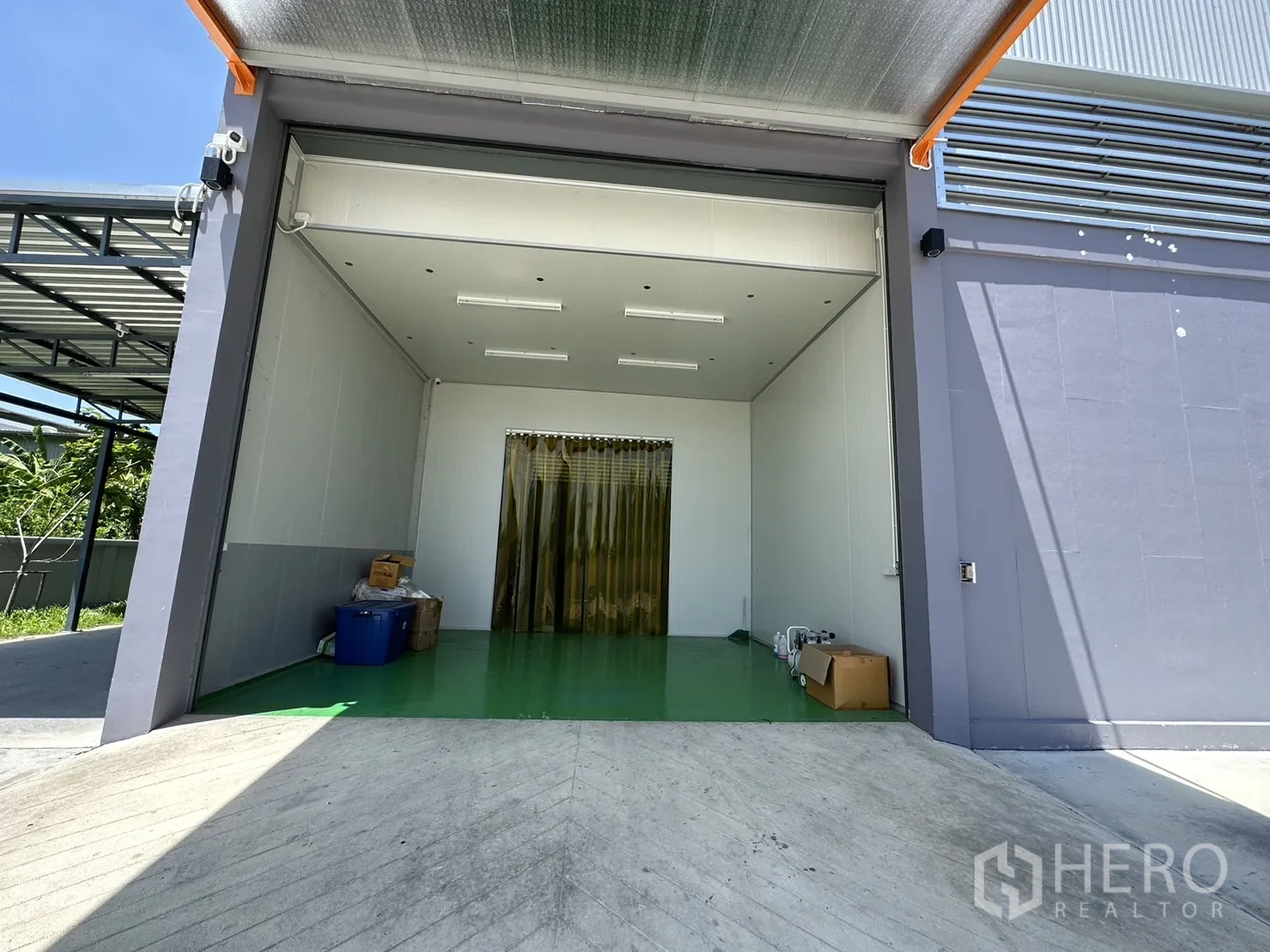 Factory for sale in Lam Luk Ka, Pathum Thani - Clean loading room with ramp and yellow PVC strip curtains.