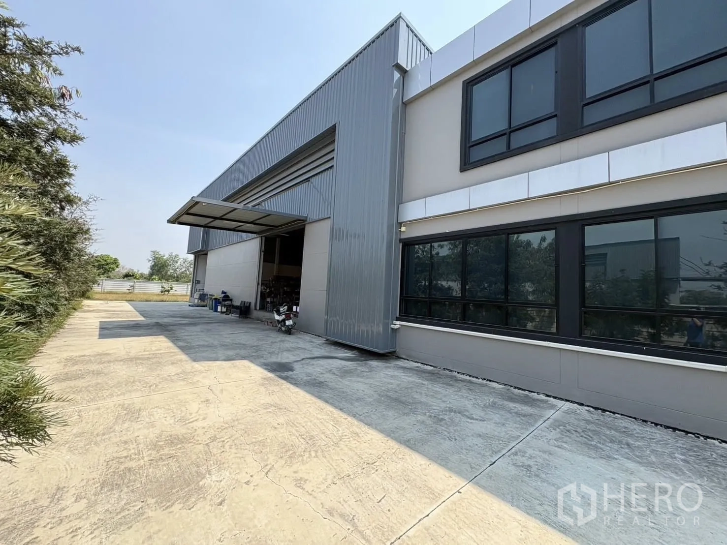 Factory for rent or sale in Bang Len, Nakhon Pathom - Side elevation showing a large roll-up loading door with canopy and a wide concrete apron.