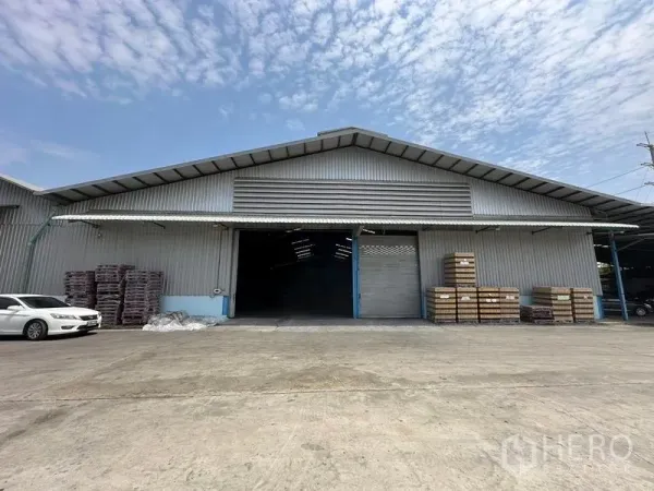 Warehouse for rent in Bang Pa-in, Phra Nakhon Si Ayutthaya - Front view of a large metal-clad warehouse with wide roller door and spacious concrete yard.