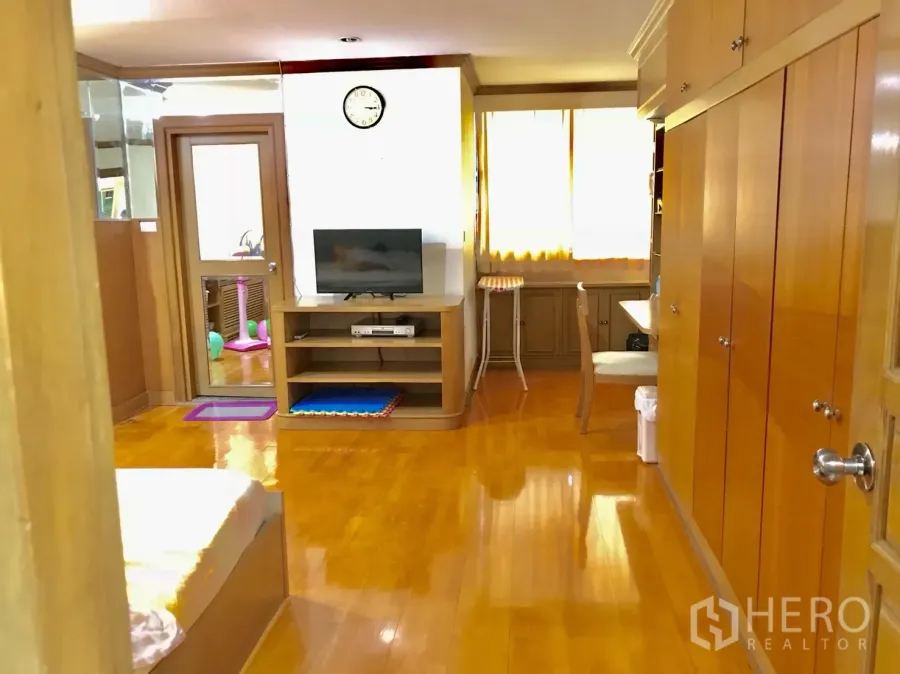 Condominium for rent in Watthana, Bangkok - Bright corridor and study area with built-in storage, TV unit and glossy hardwood floors.