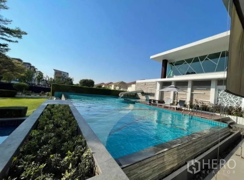 Detached House for rent in Bang Phli, Samut Prakan - Infinity-edge lap pool with sun loungers at the community clubhouse.