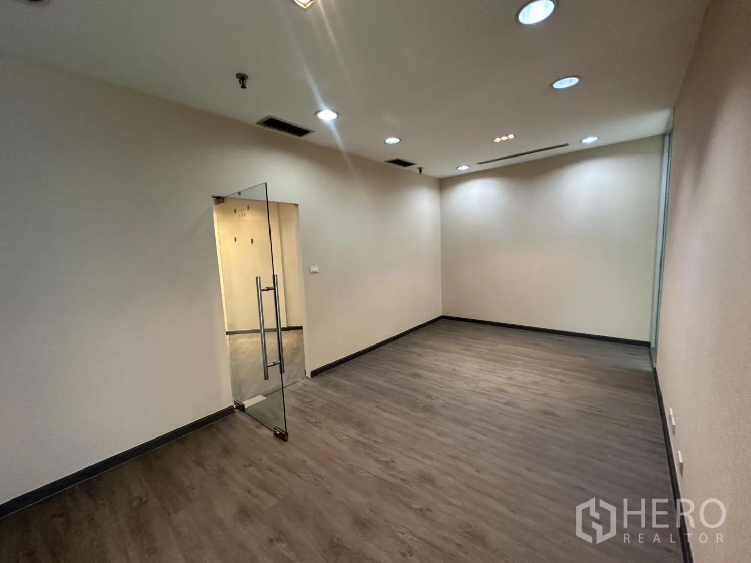 Office Space for rent in Bang Rak, Bangkok - Glass-door meeting room with recessed lighting and vinyl wood flooring.