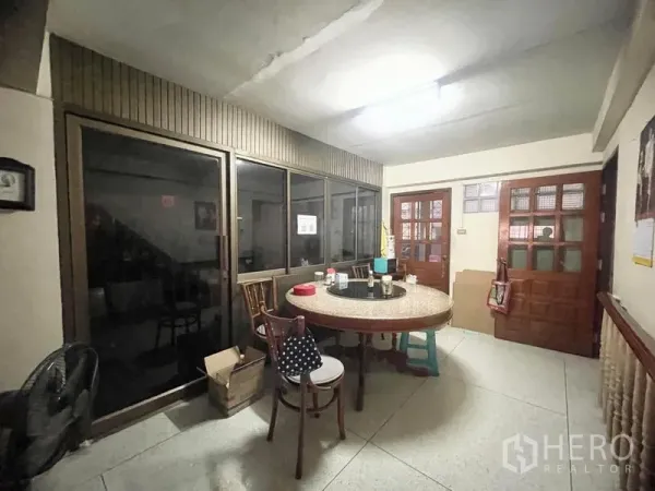 Townhouse for rent in Sathon, Bangkok - Dining area with round table, glass partition and wooden doors in a Sathon townhouse.