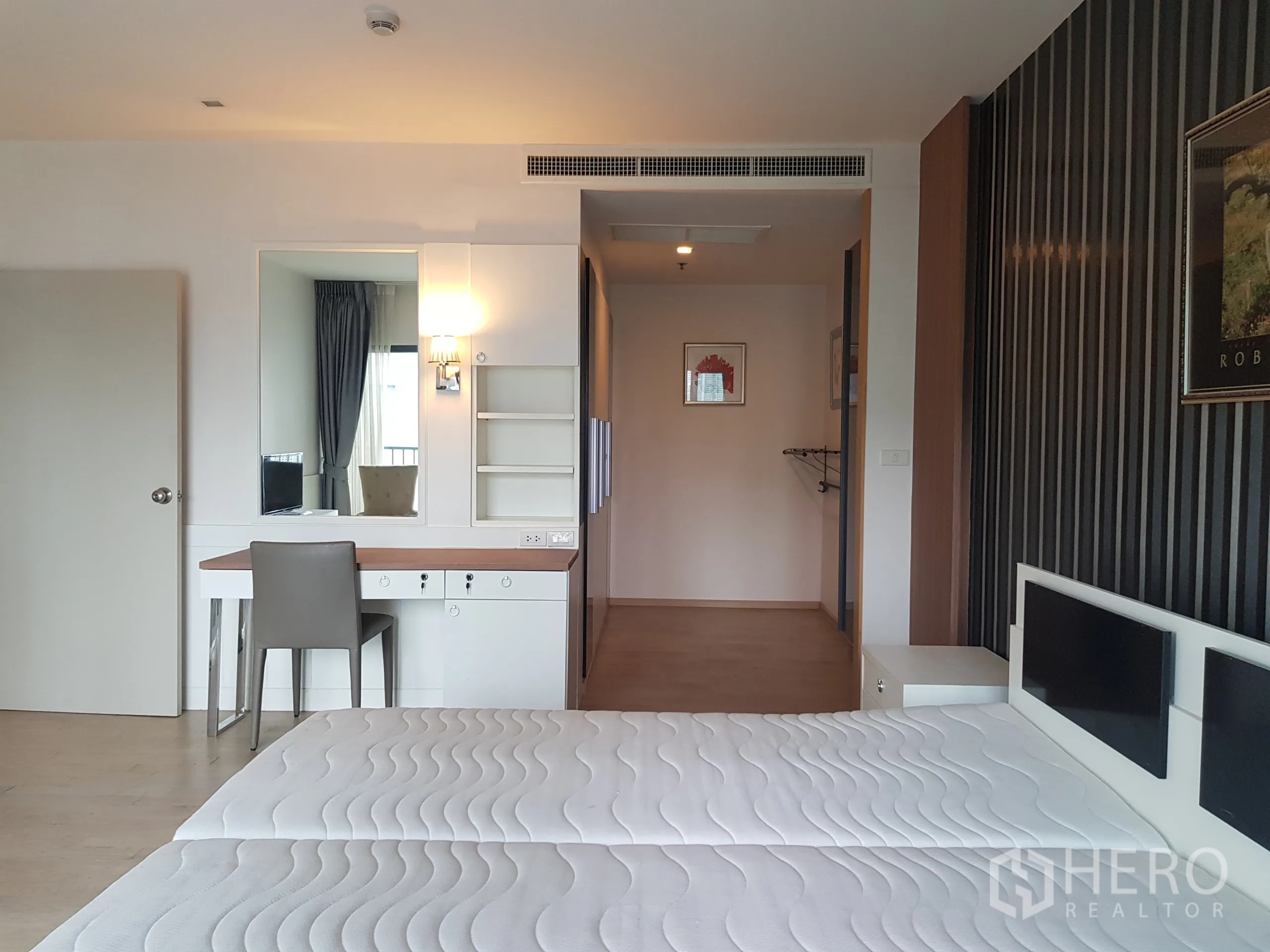 Condominium for rent in Khlong Toei, Bangkok - Bedroom corner with dressing table, wall mirror and built-in shelving.