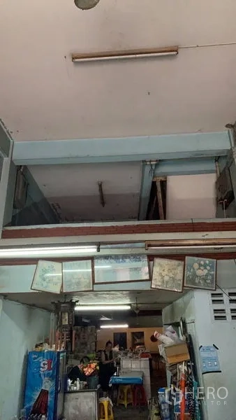 Shophouse for sale in Khlong Toei, Bangkok - Front service area with high ceiling, exposed beams and fluorescent lighting.