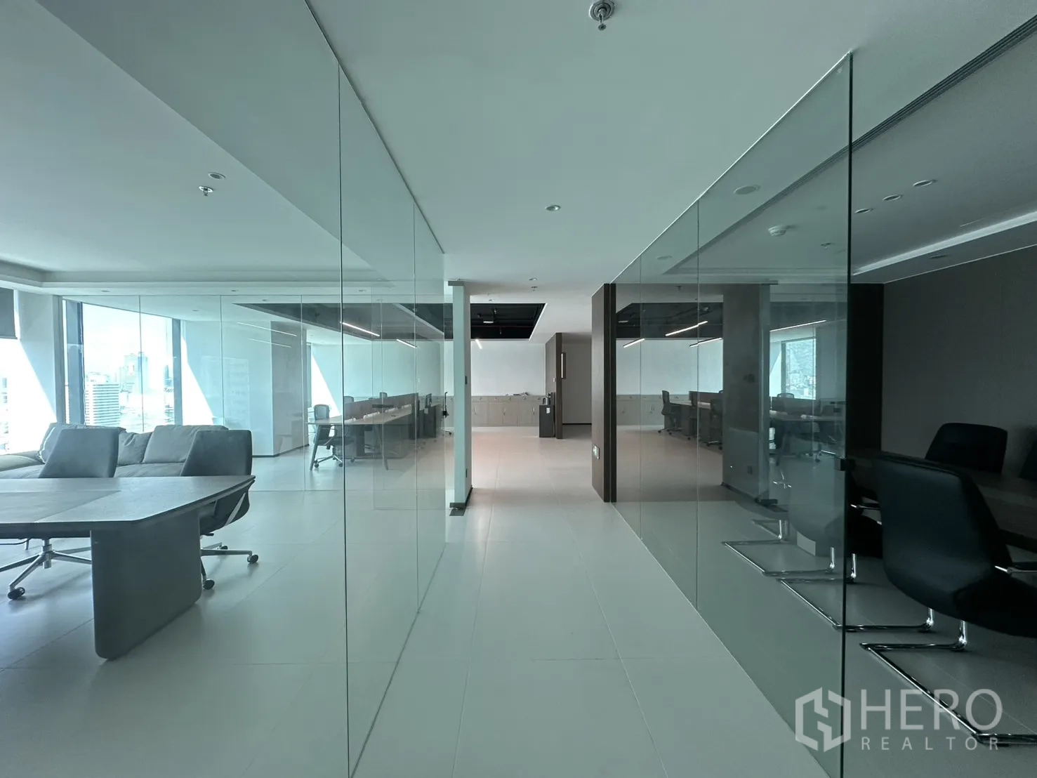 办公室 for rent in Din Daeng, Bangkok - 带落地玻璃隔断的走廊通向开放式办公与会议区。