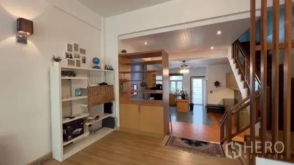 Townhouse for rent or sale in Khlong Toei, Bangkok - Open living area with shelving and a view into the kitchen and dining zone.