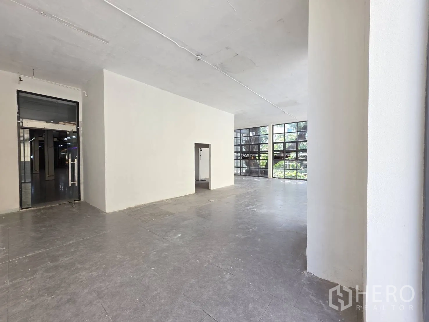 Retail Space for rent in Watthana, Bangkok - Spacious interior showing a glass entrance door, high ceiling, and bright windows.