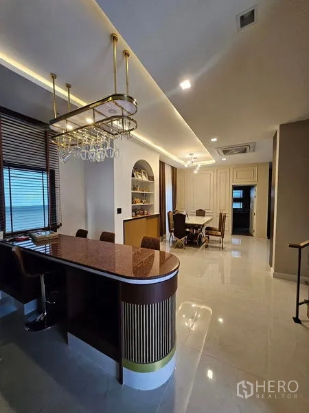 Detached House for sale in Mueang Pathum Thani, Pathum Thani - Breakfast bar with pendant glass rack and stools beside the dining area.