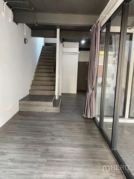 Home Office for rent or sale - Entry hall with full-height glass wall, grey flooring and staircase to upper levels.
