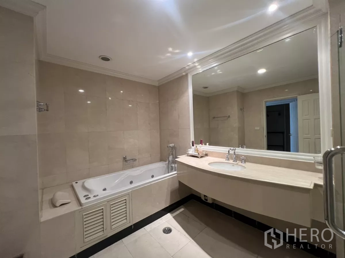 Townhouse for sale in Watthana, Bangkok - Bathroom with soaking bathtub, long vanity and full wall mirror.