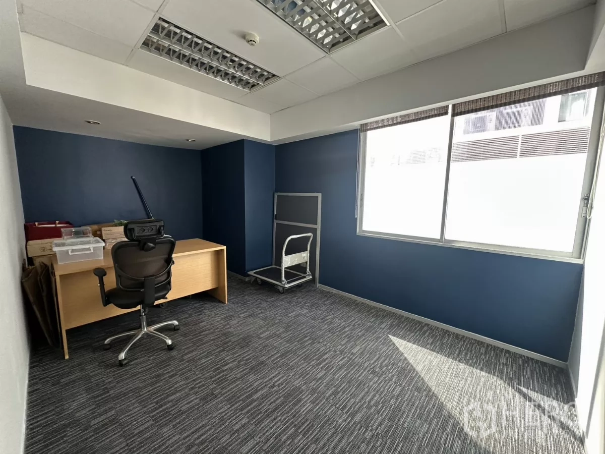 Office Space for rent in Watthana, Bangkok - Compact manager or meeting room with a desk, ergonomic chair and big window for daylight.