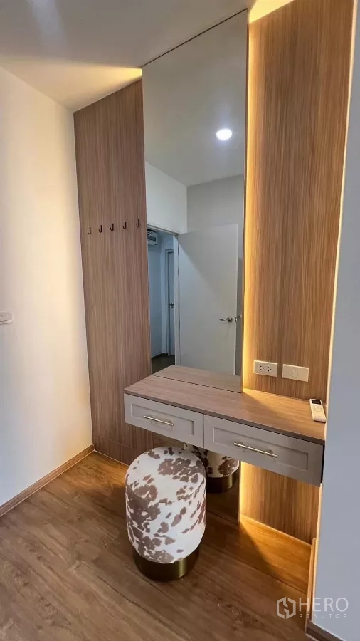 Townhouse for rent in Bang Phli, Samut Prakan - Dressing nook with built-in vanity, tall mirror and upholstered stool.