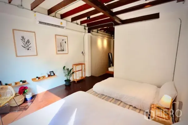 Townhouse for rent in Sathon, Bangkok - Spacious bedroom with exposed beams, double and single beds and wood floors