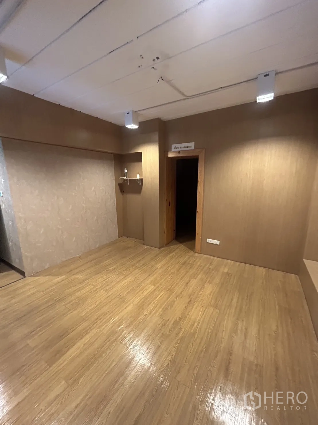 Retail Space for rent in Watthana, Bangkok - Warm-toned room with wood floors and ceiling spotlights, suitable for studio or office.