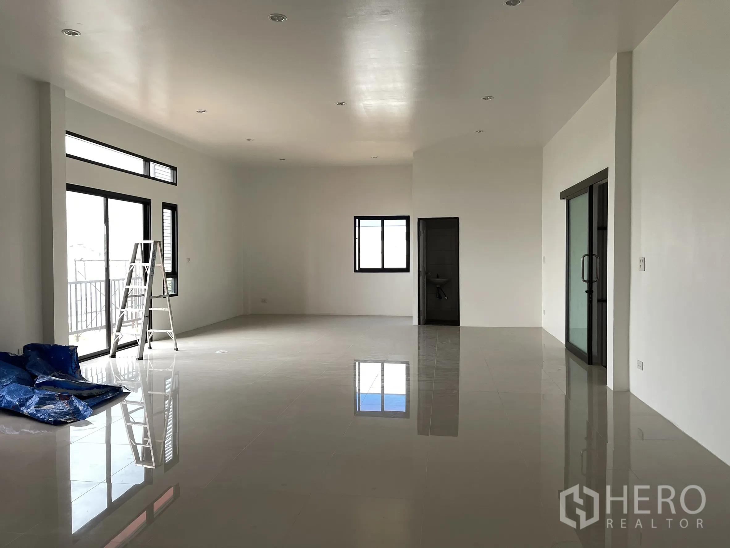Factory for rent or sale in Lam Luk Ka, Pathum Thani - Upper-floor office space with balcony doors, recessed lighting, and glass partition.