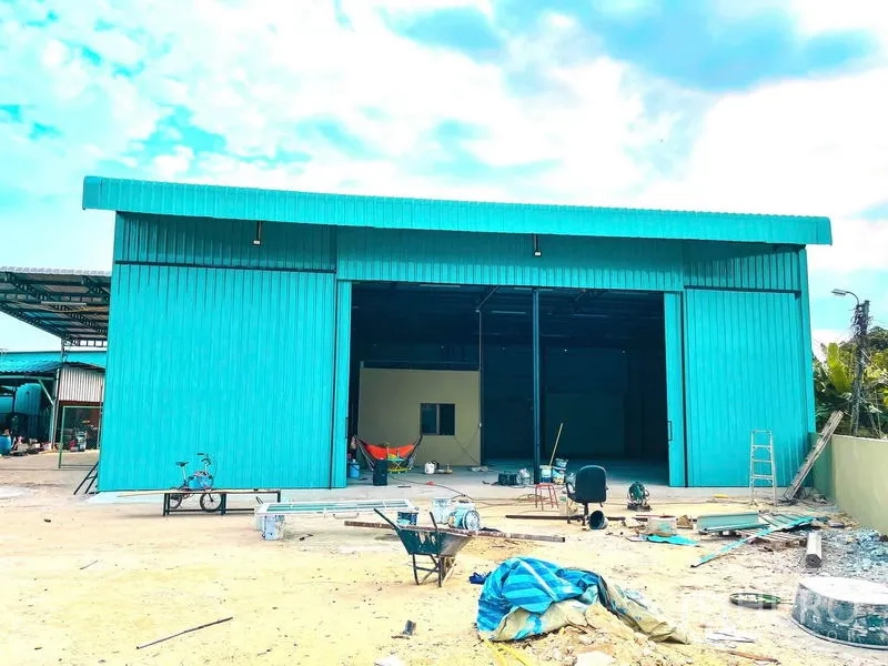 货栈 出租在Sai Mai, Bangkok - 青绿色金属外墙仓库正立面，超宽推拉门与前场空地。