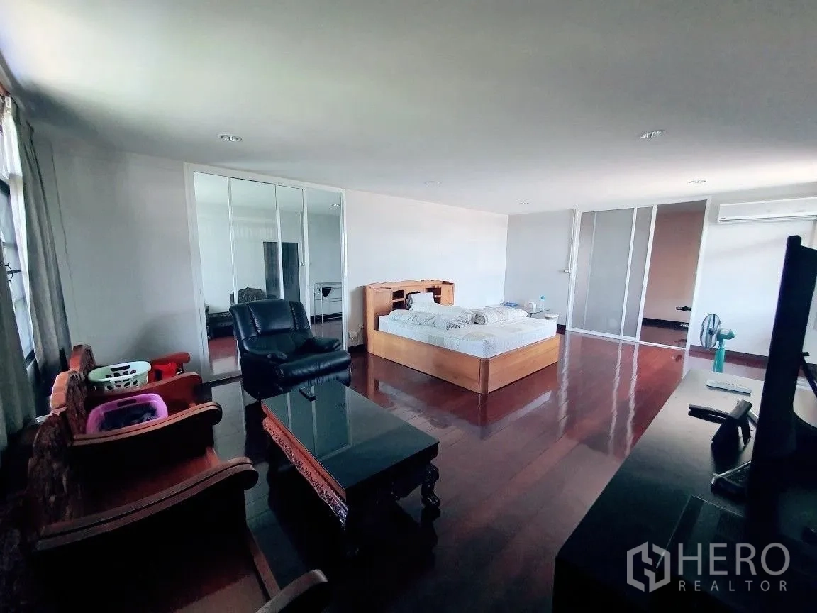Warehouse for rent in Lam Luk Ka, Pathum Thani - Large bedroom within the on-site residence featuring a bed, seating and wardrobes.