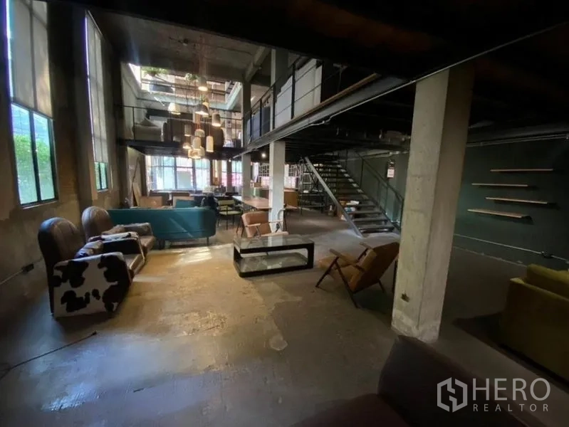 Retail Space for rent in Bang Na, Bangkok - Double-height lounge with pendant cluster, mezzanine and steel stairs.