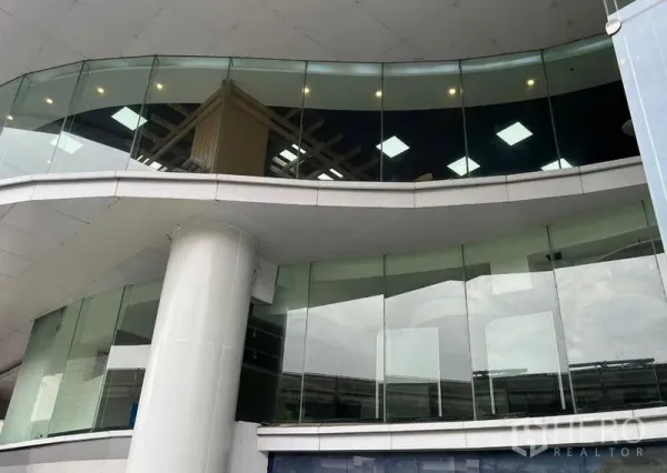 Retail Space for rent - Curved glass storefront of a modern retail unit with pillar and upper-floor windows in Silom, Bangkok.