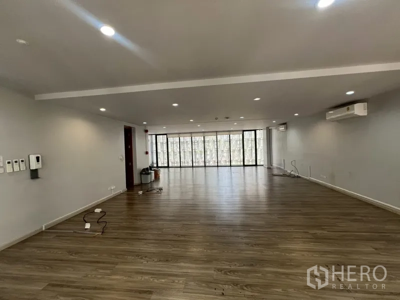 Home Office for rent or sale in Phra Khanong, Bangkok - Large open workspace with long window wall and air‑conditioning.