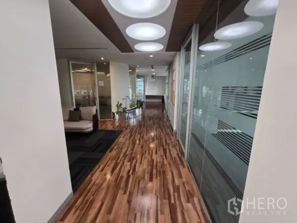 Office Space for rent in Watthana, Bangkok - Bright corridor with polished wood floor, frosted glass partitions and circular ceiling lights.