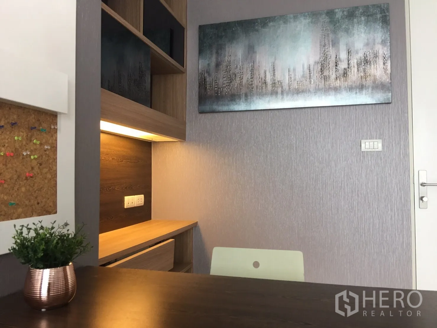 Condominium for sale in Phra Khanong, Bangkok - Cozy study corner with built-in desk, shelving, warm lighting and wall art.