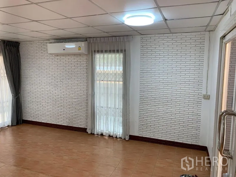 Office Space for rent in Chatuchak, Bangkok - Air-conditioned office room featuring a white brick accent wall and sheer drapes.
