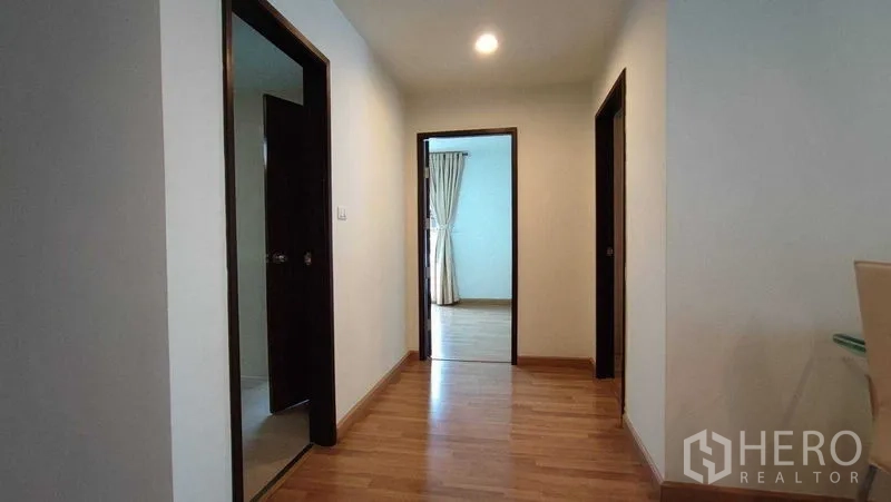 Condominium for rent in Khlong Toei, Bangkok - Hallway with warm wood flooring, recessed lighting and access to the bedrooms.