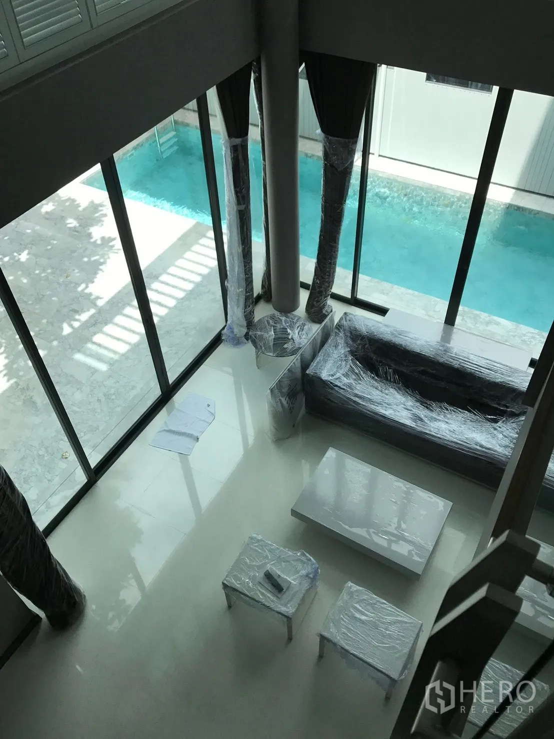 Detached House for rent in Bang Kapi, Bangkok - Double-height living room with floor-to-ceiling glass opening to a private lap pool.