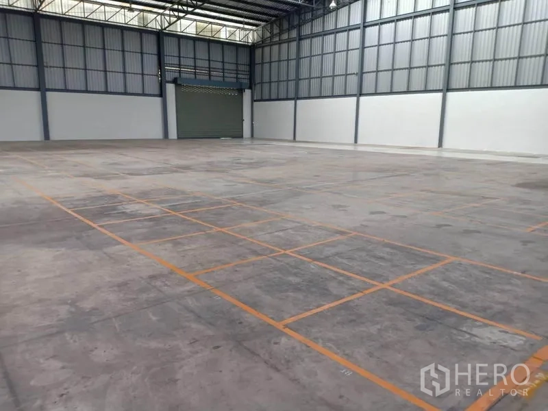 Warehouse for rent in Lat Krabang, Bangkok - Large interior space with grid floor markings and a roller door suited for logistics operations.