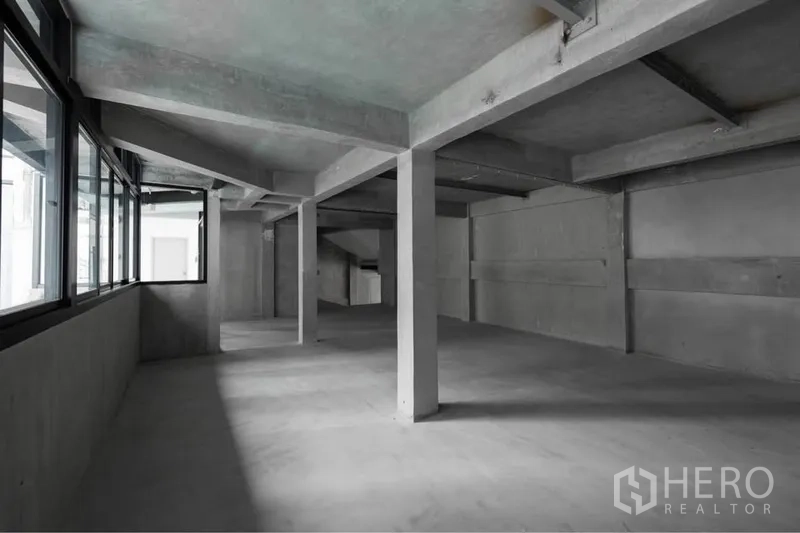Retail Space for rent in Watthana, Bangkok - Unfurnished retail interior with high ceilings, support columns, and corner windows ready for tenant fit-out.