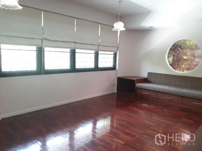 Detached House for rent in Watthana, Bangkok - Sitting room with long windows, round feature window and built-in bench with drawers